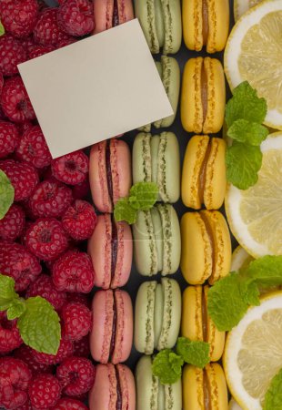 Photo for Macaroons of different colors with with raspberries, lemon and mint - Royalty Free Image