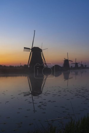 Téléchargez les photos : Traditional Dutch windmills with a colourful sky just before sunrise in Kinderdijk, The Netherlands - en image libre de droit