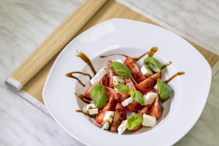 Téléchargez les photos : Tomato salad with mozzarella, basil and balsamic cream - en image libre de droit
