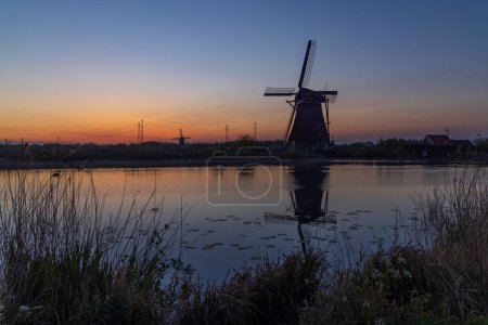 Foto de Molinos tradicionales holandeses con un cielo colorido justo antes del amanecer en Kinderdijk, Países Bajos - Imagen libre de derechos