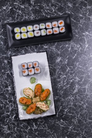 Téléchargez les photos : Ensemble de rouleaux de sushi aux fruits de mer sur fond de pierre noire - en image libre de droit