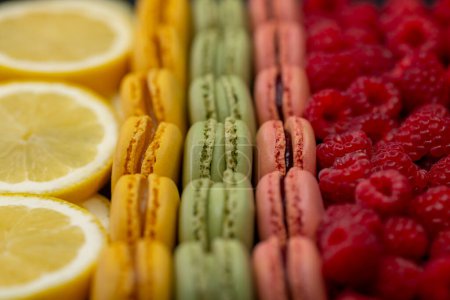 Photo for Macaroons of different colors with raspberries and lemon - Royalty Free Image