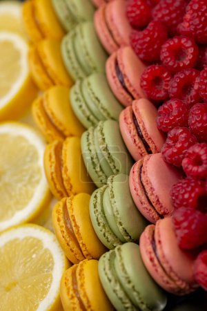 Foto de Macarrones de diferentes colores con frambuesas y limón - Imagen libre de derechos