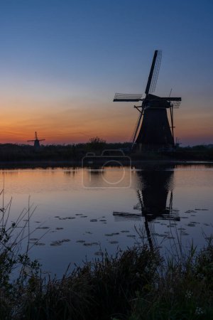 Moulins à vent traditionnels néerlandais avec un ciel coloré juste avant le lever du soleil à Kinderdijk, Pays-Bas