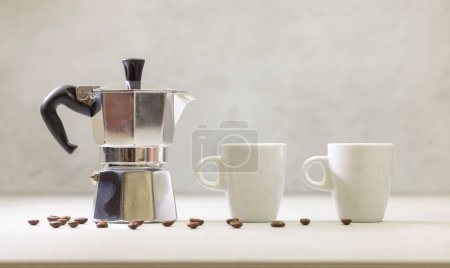 Téléchargez les photos : Cafetière geyser en métal sur table avec tasse - en image libre de droit