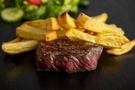 steak with fries on slate
