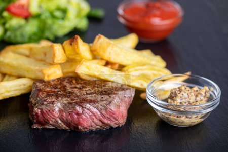 Téléchargez les photos : Steak with fries on slate - en image libre de droit