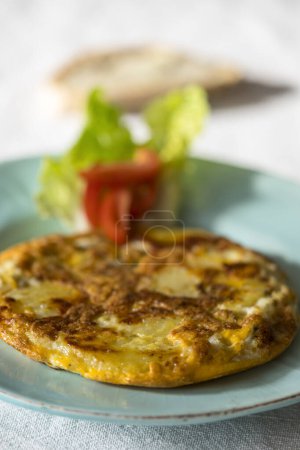 Téléchargez les photos : Tortilla espanola on a plate with tomato - en image libre de droit