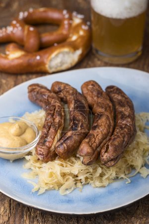 Photo for Nuremberg sausages with sauerkraut on a plate - Royalty Free Image