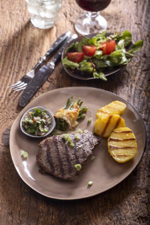 Téléchargez les photos : Steak grillé avec sauce chimichurri sur bois - en image libre de droit