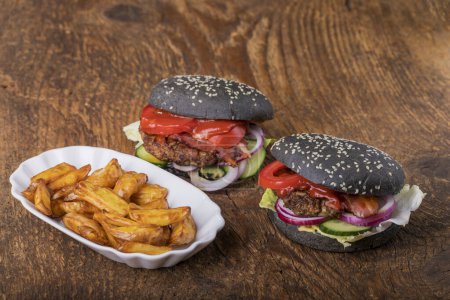 Téléchargez les photos : Gros plan de hamburgers noirs sur bois - en image libre de droit
