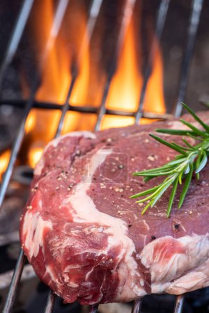 Téléchargez les photos : Steak cru au romarin sur le barbecue - en image libre de droit