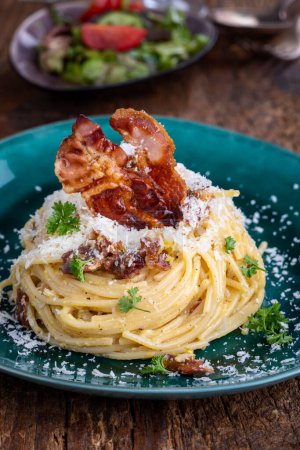Téléchargez les photos : Spaghetti carbonara avec salade sur bois - en image libre de droit