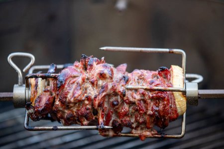 Téléchargez les photos : Doner de la viande sur une brochette sur le barbecue - en image libre de droit