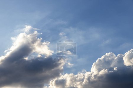Foto de El cielo azul tiene nubes oscuras en la parte inferior de la imagen. y la luz del sol brilla desde la esquina inferior izquierda de la imagen - Imagen libre de derechos