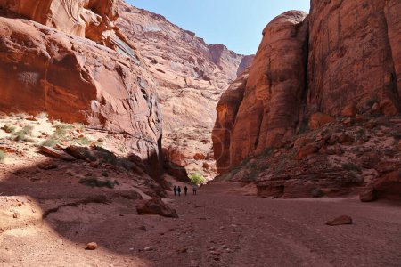 Four hikers dwarfed by the huge canyon walls of Waterholes Canyon.  This is the part of canyon accessible from the Colorado River.