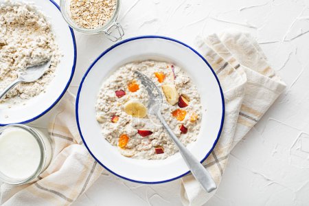 Photo for Oatmeal plate. A plate of oatmeal served with fresh fruit and milk. Healthy food, diet. Top view. - Royalty Free Image