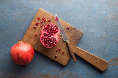 Photo for Cutting Fresh pomegranate for healthy meal on table background - Royalty Free Image