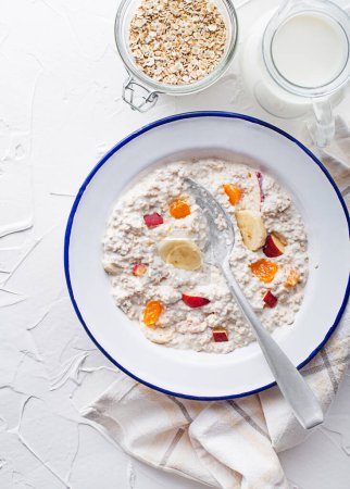 Photo for Oatmeal plate. A plate of oatmeal served with fresh fruit and milk. Healthy food, diet. Top view. - Royalty Free Image
