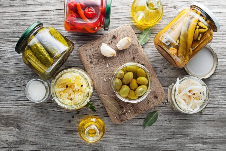 Photo for Canned and pickled vegetables in glass jars on wooden table. Preserved food - Royalty Free Image