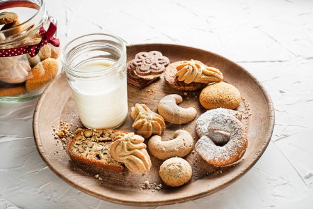 Téléchargez les photos : Un verre de lait et une variété de biscuits au sucre frais faits maison au beurre et aux noix - en image libre de droit