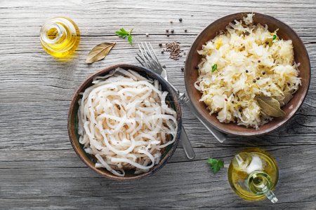 Téléchargez les photos : Traditional healthy sauerkraut and sour turnip on wooden background. - en image libre de droit