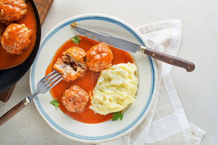 Photo for Fried meatballs braised in tomato sauce served with mashed potatoes on white table. Eating Beef roasted meatballs in tomato sauce. - Royalty Free Image