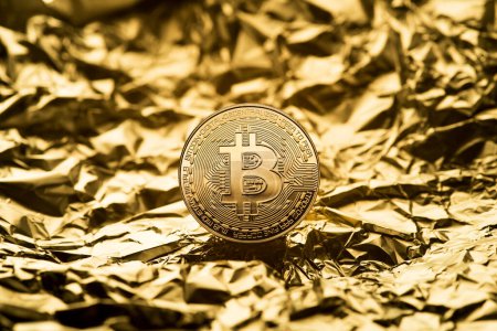 Téléchargez les photos : Golden coin with bitcoin symbol close up. Bitcoin and cryptocurrency investing concept. Bitcoin cryptocurrency coin. Trading on the cryptocurrency exchange. Trends in bitcoin exchange rates. - en image libre de droit