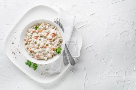 Photo for Bowl of russian salad olivier french salad with vegetables and egg dressed with mayonnaise on white table - Royalty Free Image