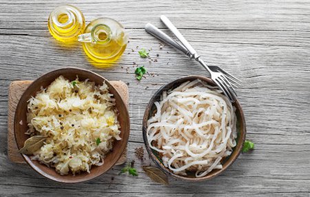 Photo for Traditional fresh and healthy sauerkraut and sour turnip on wooden background. - Royalty Free Image