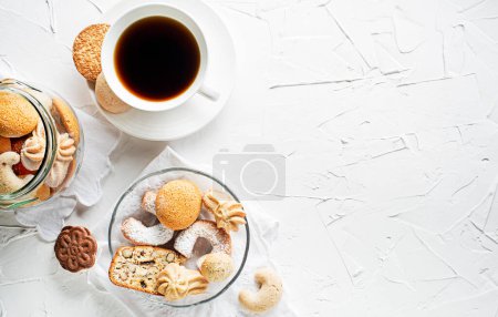 Photo for Tasty homemade sugar cookies and biscuits of all shapes and sizes with fresh coffee cup - Royalty Free Image