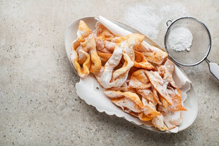 Photo for Traditional sweet crisp pastry - faworki or angel wings, deep-fried and sprinkled with powdered sugar - Royalty Free Image