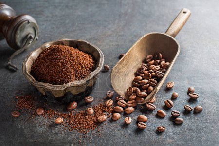 Foto de Coffee beans and freshly ground coffee powder on grey stone background close up - Imagen libre de derechos