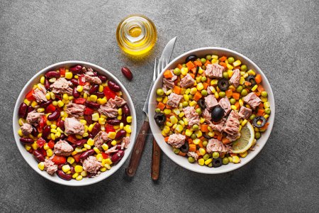 Photo for Healthy tuna salads mixed with corn, peppers, carrot, peas and beans on grey background. Mexican corn salad. - Royalty Free Image