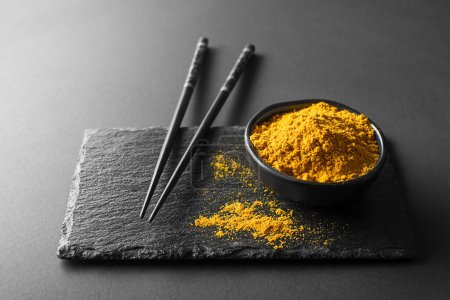 Photo for Dry turmeric powder(curcuma) in cup closeup. Turmeric is one of the key ingredients in many Asian dishes - Royalty Free Image