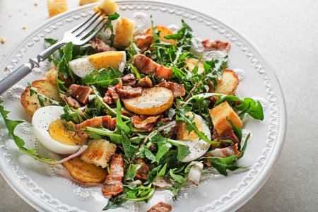 Photo for Dandelion salad with egg bacon potato and croutons close up - Royalty Free Image