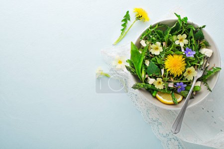 Foto de Ensalada de primavera con diente de león, espárragos, ajo silvestre, flores, ortiga y queso crema. Ingredientes alimentarios desintoxicación primavera saludable. - Imagen libre de derechos