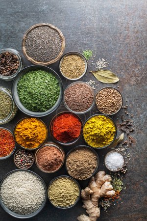 Téléchargez les photos : Herbes et épices colorées pour cuisiner le repas. Épices indiennes et asiatiques Sur fond de pierre grise. Vue du dessus. - en image libre de droit