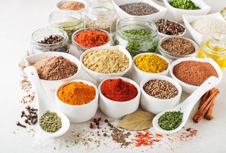 Photo for Colorful herbs and spices for every cooking style and in every kitchen. Indian and asian and japanese spices on white stone background close up - Royalty Free Image