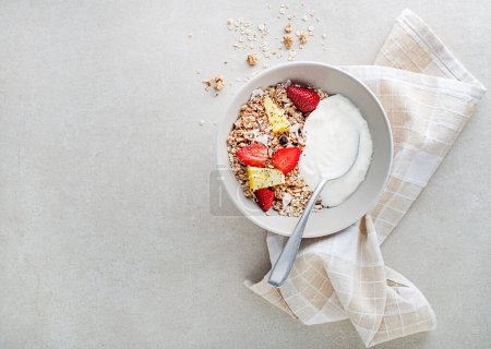 Foto de Un plato de granola seca servido con fruta fresca y yogur. Plato de avena. Comida saludable, dieta. Vista superior. - Imagen libre de derechos