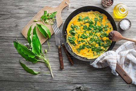 Photo for Spring omelette with fresh ramson or wild garlic leaves. Healthy spring diet food concept. - Royalty Free Image