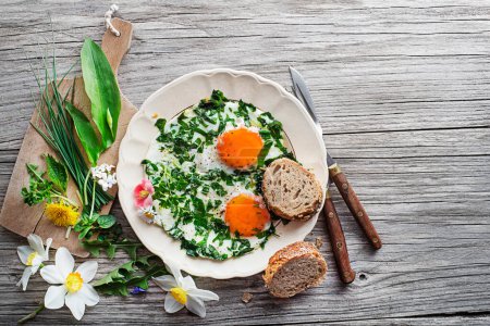Foto de Huevos fritos con plantas y hierbas frescas de primavera. Dieta saludable de primavera concepto de alimentos. - Imagen libre de derechos