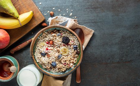 Foto de Un tazón de granola seca y muesli servido con fruta fresca. Desayuno de avena. Comida saludable, dieta. Vista superior. - Imagen libre de derechos