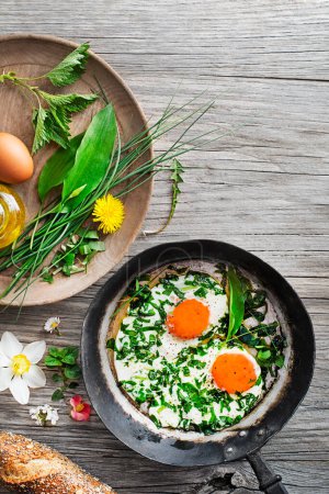 Photo for Fried eggs with fresh spring plants and herbs. Healthy spring food concept. - Royalty Free Image
