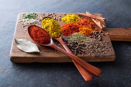 Téléchargez les photos : Herbes et épices colorées pour cuisiner des plats. Épices indiennes et asiatiques Sur fond de pierre grise gros plan. - en image libre de droit