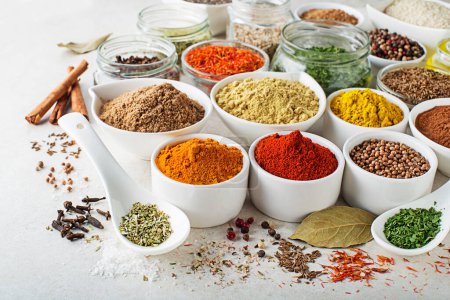 Photo for Colorful herbs and spices for cooking meal. Indian and Asian spices On white stone background closeup - Royalty Free Image