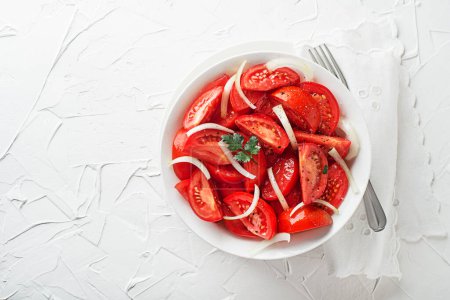 Photo for Fresh tomato salad with onion and parsley on white table background. Concept for a tasty and healthy meal - Royalty Free Image