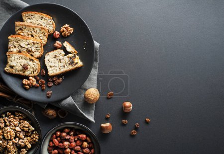 Téléchargez les photos : Tasty traditional homemade biscotti biscuits on black table background. Delicious cantucci cookies with nuts and raisin. - en image libre de droit