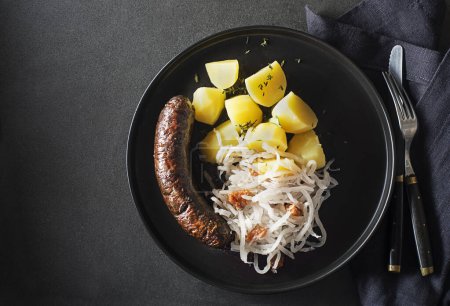 Téléchargez les photos : Morcille sanglante à la saucisse, navet aigre-ragoût et pomme de terre en gros plan. Plat slovène traditionnel à la saucisse sanglante rôtie - en image libre de droit