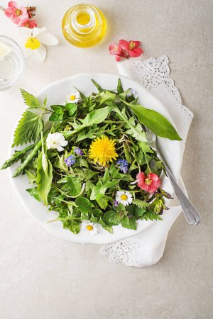 Photo for Spring salad with flowers, herbs and plants. Wild garlic, nettle, dandelion and other medicinal herbs and wild edible plants growing in early spring. - Royalty Free Image